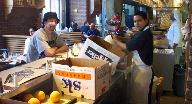 Willie watches oranges being converted to juice at Eggspectation. Montreal.